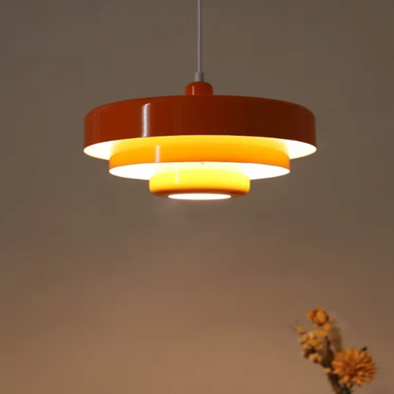 Bauhaus Metal LED Pendant Light in vibrant orange, green, and white with three-tier design illuminating a modern room.