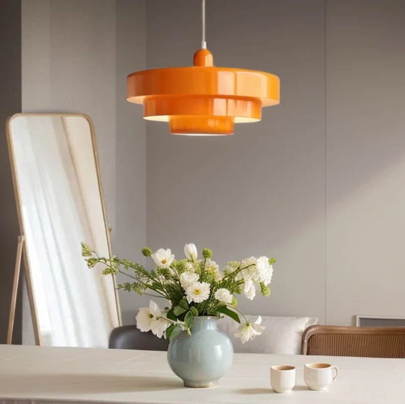 Bauhaus Metal LED Pendant Light in vibrant orange, green, and white with three-tier design illuminating a modern room.