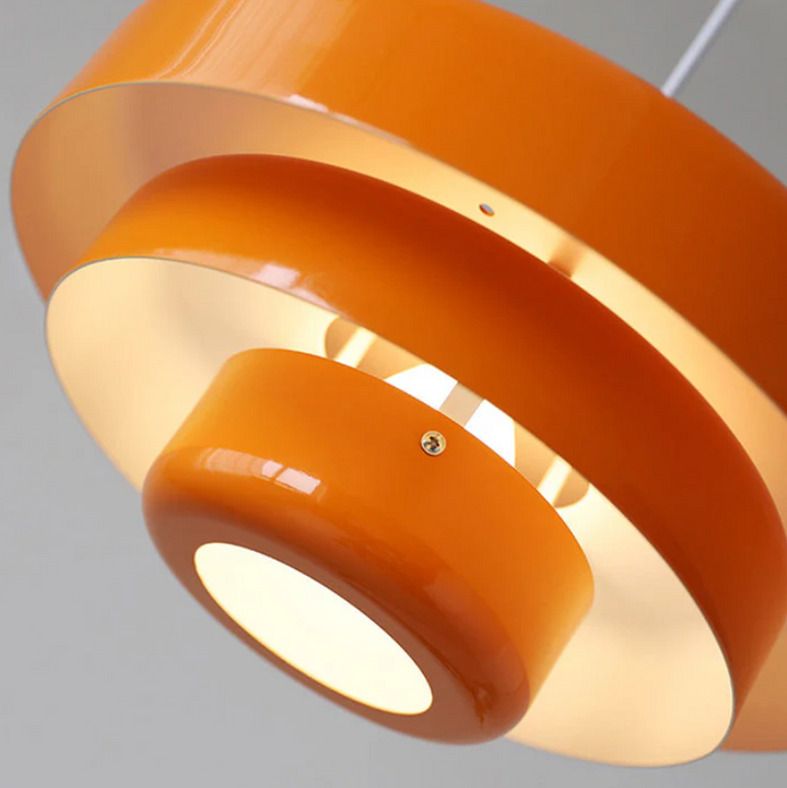 Bauhaus Metal LED Pendant Light in vibrant orange, green, and white with three-tier design illuminating a modern room.
