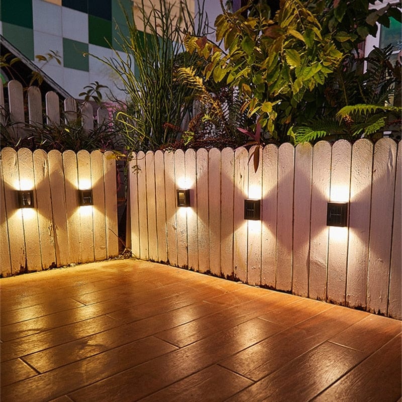 "Eco-friendly solar wall light illuminating garden fence at night; warm white LED, sleek, modern outdoor lighting."