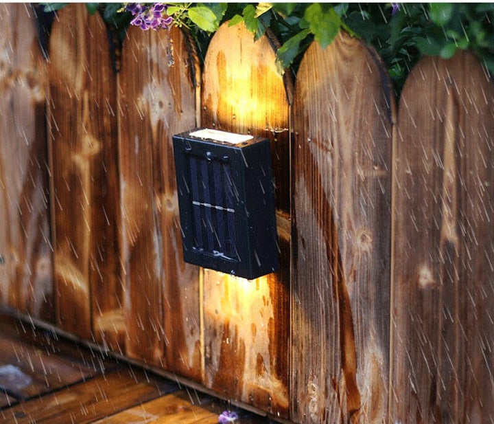 "Eco-friendly solar wall light illuminating garden fence at night; warm white LED, sleek, modern outdoor lighting."