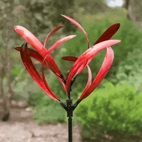 Elegant metal wind spinner for garden, showing smooth rotation and vibrant red and blue colors, enhancing outdoor decor.