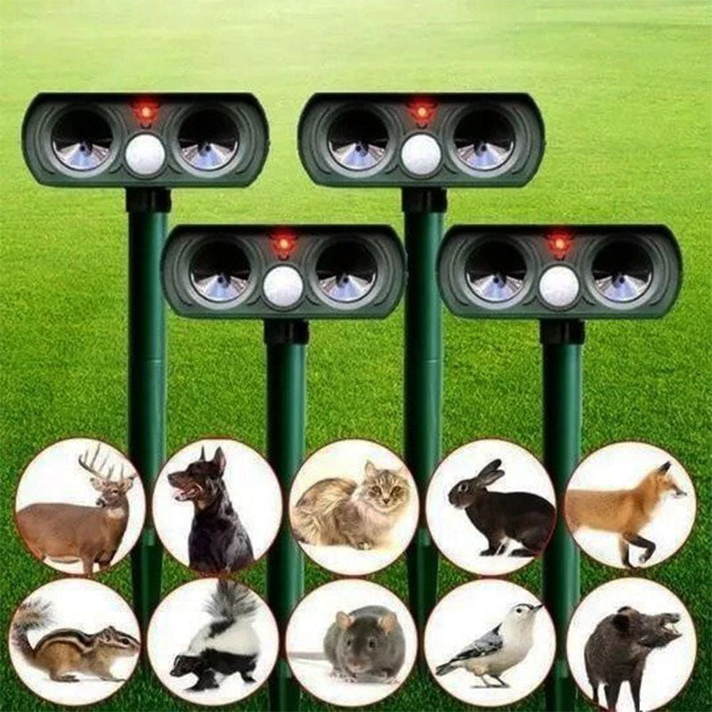 "Infrared solar animal pest repeller with ultrasonic technology in garden setting, solar panel atop a green weatherproof devi