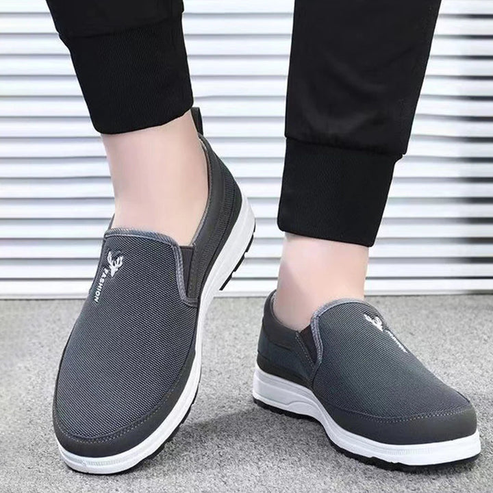Men's cushioned slip-on walking shoes with breathable mesh, elastic panels, and grip outsole for comfort and stability.