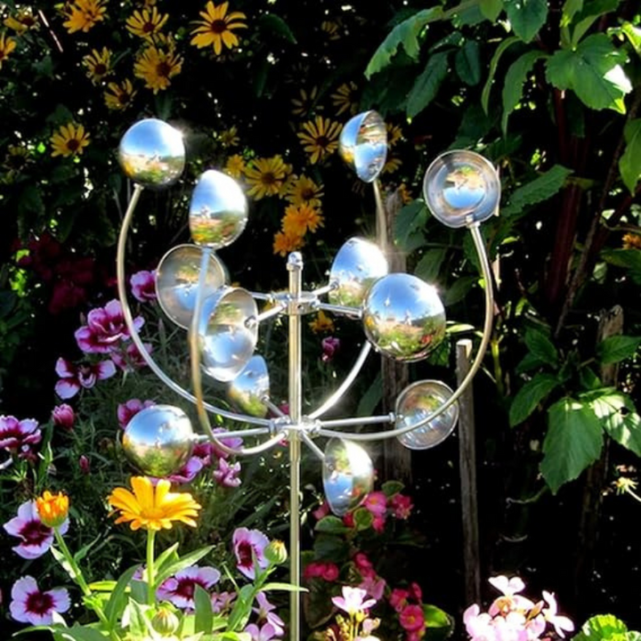 Metallic wind spinner with sleek design and reflective finish, spinning gracefully in a garden setting for outdoor elegance.