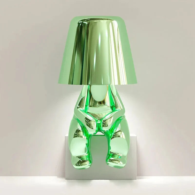 Modern metallic figurine table lamp featuring a 'Thinker' sculpture design, emits a warm LED glow, perfect for elegant decor.
