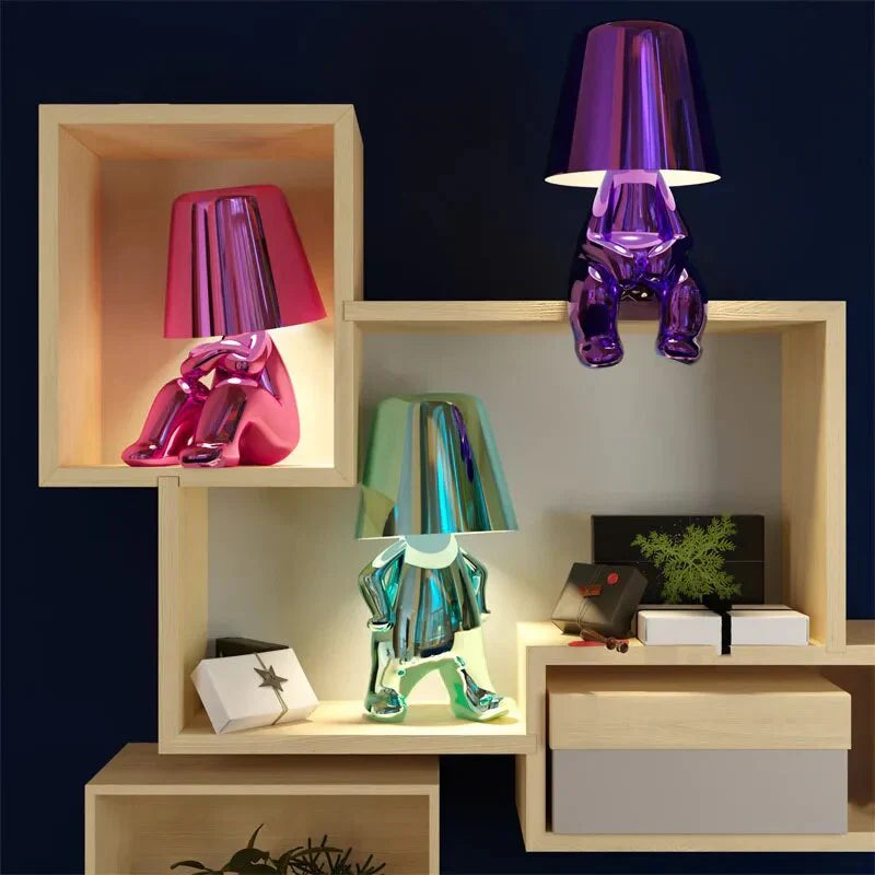 Modern metallic figurine table lamp featuring a 'Thinker' sculpture design, emits a warm LED glow, perfect for elegant decor.