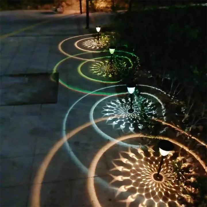 "Solar LED Mandala Garden Light casting intricate shadows on pathway, showcasing artistic outdoor illumination at night."