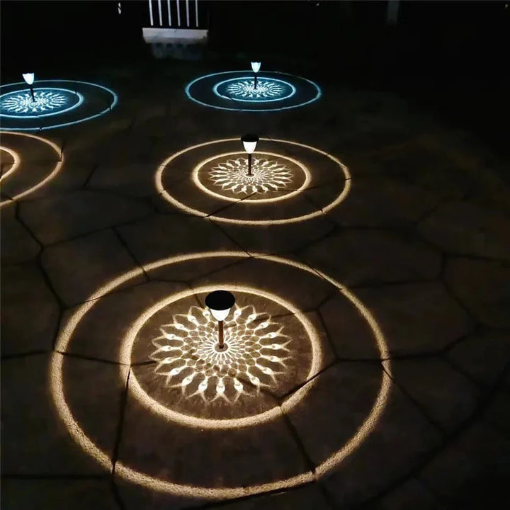 "Solar LED Mandala Garden Light casting intricate shadows on pathway, showcasing artistic outdoor illumination at night."