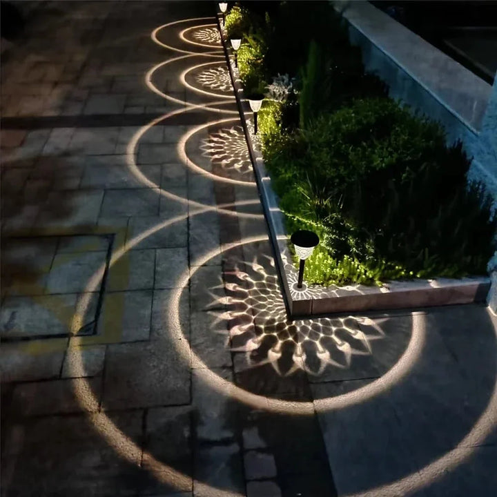 "Solar LED Mandala Garden Light casting intricate shadows on pathway, showcasing artistic outdoor illumination at night."