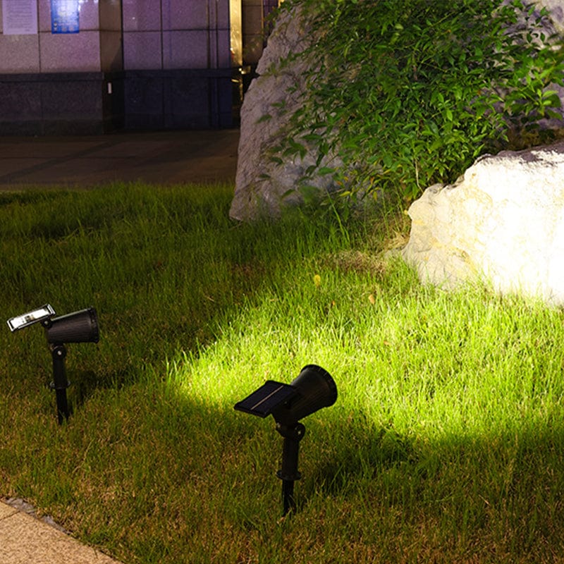 Solar-powered LED garden spotlight with sleek black design, adjustable head, and vibrant RGB lighting for outdoor use.