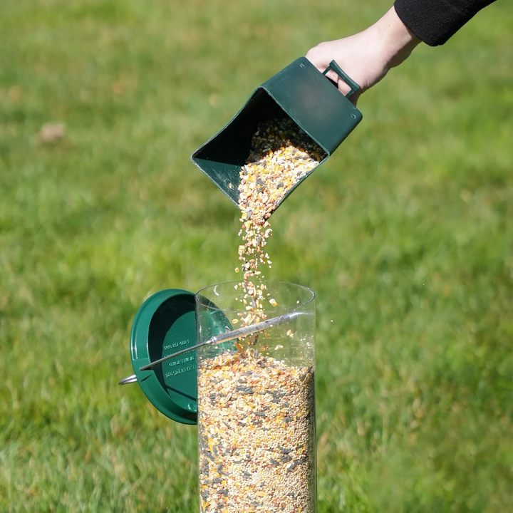 Squirrel-proof metal bird feeder with spinning perch, hanging outdoors, features four feeding ports and weather-resistant des