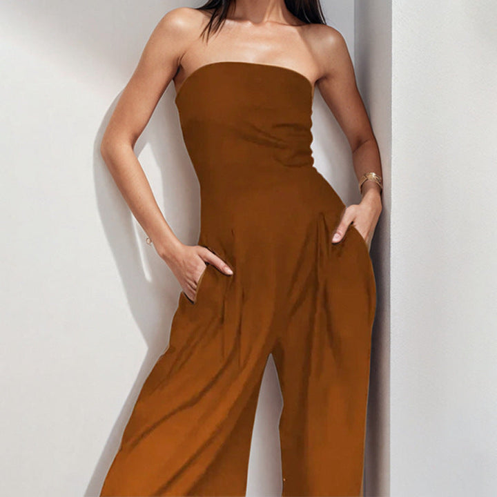 "Woman in strapless satin jumpsuit with tailored bodice, wide-leg cut, available in elegant colors like black and navy."